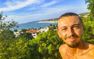 Selfie with rocks cliffs view waves beach Puerto Escondido Mexico. photo