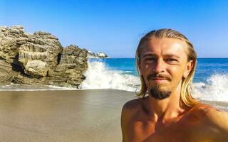 Selfie with rocks cliffs view waves beach Puerto Escondido Mexico. photo