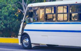 Various colorful buses tour bus transport in Puerto Escondido Mexico. photo