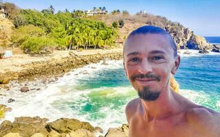 Selfie with rocks cliffs view waves beach Puerto Escondido Mexico. photo