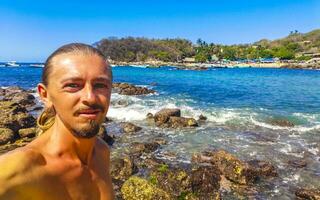 Selfie with rocks cliffs view waves beach Puerto Escondido Mexico. photo
