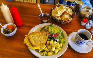 Toast with scrambled eggs salad onions avocado tomatoes potatoes Mexico. photo