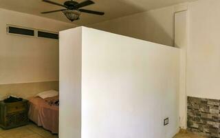 Simple small apartment hotel room with bed table in Mexico. photo