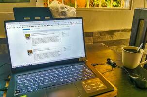 Playa del Carmen Quintana Roo Mexico 2023 Laptop work at table with coffee cup in Mexico. photo
