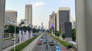 Jakarta, Indonesia - July 10, 2022. Capital highway between skyscrapers with heavy vehicle traffic. photo