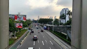 Jakarta, Indonesia - July 10, 2022. Capital highway between skyscrapers with heavy vehicle traffic. photo