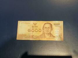 One 1000 Baht note on a black background. photo