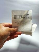 Bekasi, Indonesia on December 1, 2022. A hand is holding a receipt from a restaurant called Hangry photo