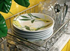 Different clean plates in dish drying rack on kitchen counter. Created with Generative AI technology. photo
