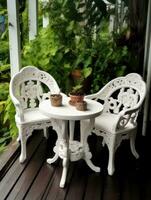 Garden white chairs and a table with flowers against the backdrop of greenery and the building. Created with Generative AI technology. photo