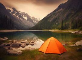 tourist lit tent by the lake at sunset. Dramatic sky. Orange lit inside the tent and a fire over the misty river at sunset. Dramatic sunset. Summer landscape. Created with Generative AI technology. photo