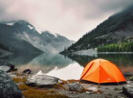 tourist lit tent by the lake at sunset. Dramatic sky. Orange lit inside the tent and a fire over the misty river at sunset. Dramatic sunset. Summer landscape. Created with Generative AI technology. photo