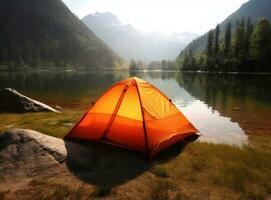 tourist lit tent by the lake at sunset. Dramatic sky. Orange lit inside the tent and a fire over the misty river at sunset. Dramatic sunset. Summer landscape. Created with Generative AI technology. photo