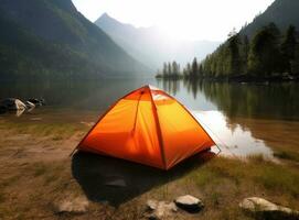 tourist lit tent by the lake at sunset. Dramatic sky. Orange lit inside the tent and a fire over the misty river at sunset. Dramatic sunset. Summer landscape. Created with Generative AI technology. photo