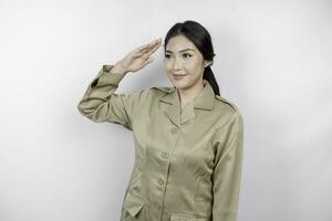 un joven asiático gobierno trabajador vistiendo un marrón uniforme haciendo saludo pose, aislado por blanco antecedentes foto