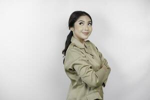 A beautiful Asian woman wearing brown uniform smiling at the camera, isolated by white background. Indonesian government employees uniform. photo