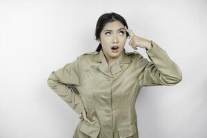 Mad civil worker woman wearing a brown uniform feeling so stressed. Indonesian government employees overworked concept. photo