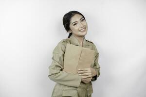 un joven y hermoso trabajador asiático con uniforme marrón que trae un documento. pns indonesios. foto