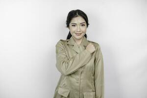 A young Asian government worker wearing a brown uniform doing salute pose, isolated by white background photo