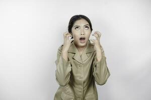 Mad civil worker woman wearing a brown uniform feeling so stressed. Indonesian government employees overworked concept. photo