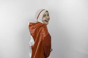 contento sonriente indonesio musulmán mujer vistiendo rojo parte superior y blanco hijab participación de indonesia bandera a celebrar Indonesia independencia día. aislado por blanco antecedentes. foto