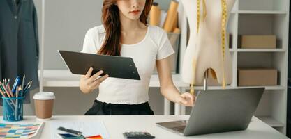 Young woman running online store Startup small business SME, using smartphone or tablet receive and checking online purchase shopping order photo
