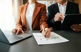 Business documents on office table with smart phone and calculator digital tablet and graph photo