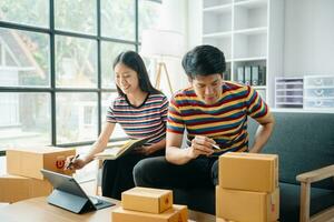 young Asian man and woman at office of their business online shopping.In home office photo