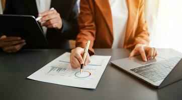 Business documents on office table with smart phone and calculator digital tablet and graph photo