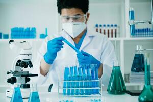 Scientist mixing chemical liquids in the chemistry lab. Researcher working in the chemical laboratory photo