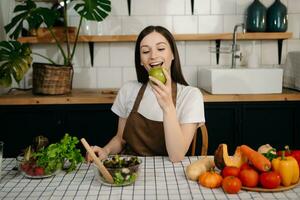 young woman with cutting board of cut lettuce at kitchen. healthy food concept photo