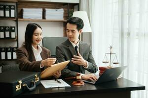 Business Asian people and lawyers discussing contract papers sitting at the table. Concepts of law, advice, legal services. photo