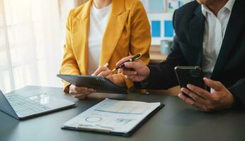 Business documents on office table with smart phone and calculator digital tablet and graph photo