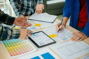 UX developer and ui designer brainstorming about mobile app interface wireframe design with customer breif and color code at modern office. photo