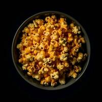 Popcorn in a bowl on a black background. Top view. photo