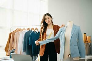 Diverse female fashion designers at work with tailor centimeters on necks and holds tablet and smartphone. independent creative design photo