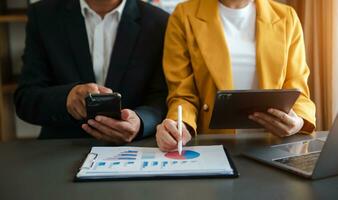 Business documents on office table with smart phone and calculator digital tablet and graph photo