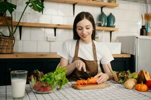 young woman with cutting board of cut lettuce at kitchen. healthy food concept photo