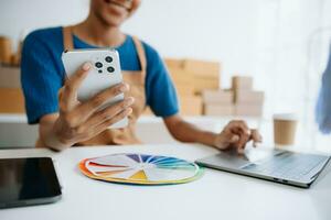 Young woman holding a smartphone, tablet showing payment success and credit card with yellow parcel box as online shopping concept photo