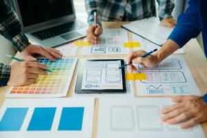 UX developer and ui designer brainstorming about mobile app interface wireframe design with customer breif and color code at modern office. photo