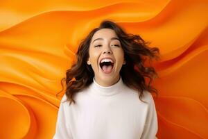 Happy woman standing on orange background shocked photo