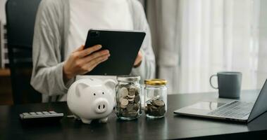 Women are putting coins in a piggy bank for a business that grows for profit and saving money for the future. planning for retirement concept photo