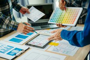 UX developer and ui designer brainstorming about mobile app interface wireframe design with customer breif and color code at modern office. photo