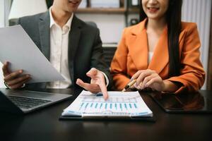 Businessman and team analyzing financial statement Finance task. with smart phone and laptop and  tablet. Wealth management concept photo