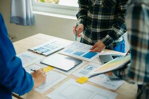 UX developer and ui designer brainstorming about mobile app interface wireframe design with customer breif and color code at modern office. photo