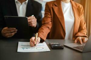 Business documents on office table with smart phone and calculator digital tablet and graph photo