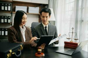 Business Asian people and lawyers discussing contract papers sitting at the table. Concepts of law, advice, legal services. photo