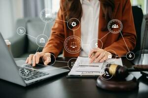 justice and law concept. Female judge in a courtroom the gavel, working with smart phone and laptop and digital tablet computer on table with VR icon photo