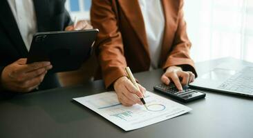 Business documents on office table with smart phone and calculator digital tablet and graph photo