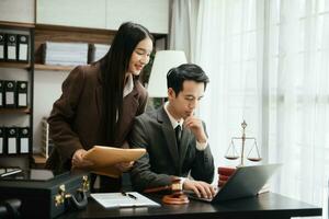 Business Asian people and lawyers discussing contract papers sitting at the table. Concepts of law, advice, legal services. photo